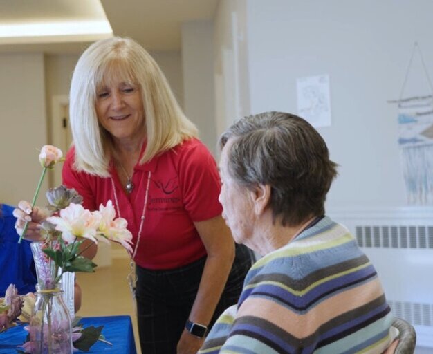 resident and staff arranging flowers